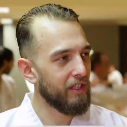 Portrait-Foto eines jungen Mannes im Dobok als Testimonial für unsere Taekwondo Erwachsenen Kurse.