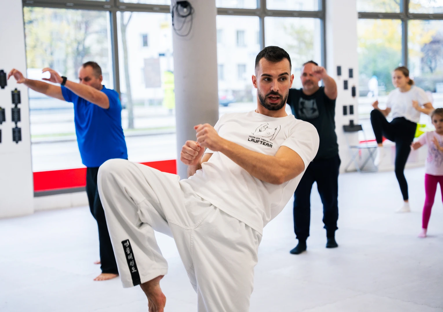 Selbstverteidigungskurse für Erwachsene: Ein Mann übt konzentriert Tritttechniken im hellen Studio.